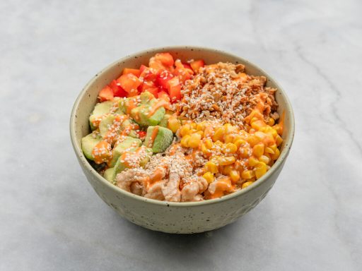 Frisch zubereitete Bowl mit Chicken, Avocado, Mais und Paprika