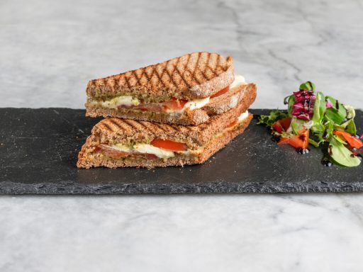 Hausgemachtes Sandwich mit Tomate, Mozarrela und Salat als Beilage