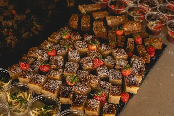 Apfelkuchen in Stücke geschnitten, mit Erdbeeren drapiert