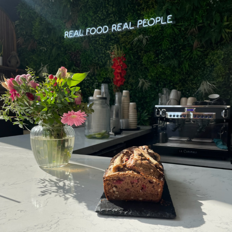 Hausgemachtes Bananabread vor Neon-Logo Real Food Real People