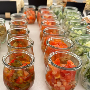 Weckgläser gefüllt mit Antipasti, Tomaten- und Gurkensalat für ein Catering