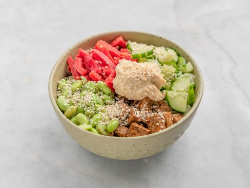 Frisch zubereitete Bowl mit Tofu, Edamame, Gurke und Hummus